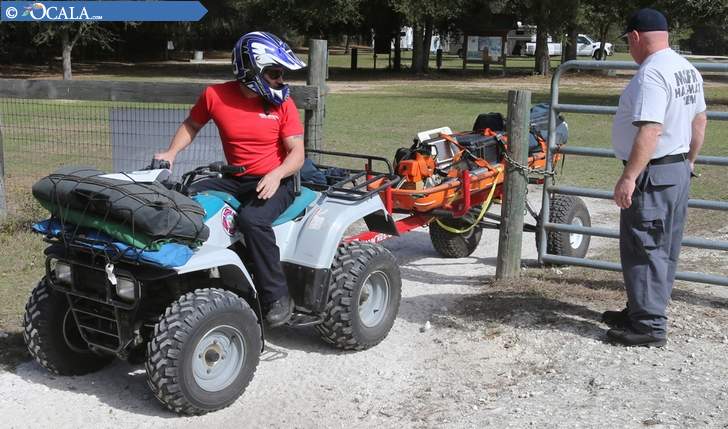 "Mick Jasper, left, and Lt. Joe Fitzpatrick of Marion County Fire Rescue pull an ATV through a gate as they respond to a mock emergency call during a training exercise at the Marjorie Harris Carr Cross Florida Greenway Land Bridge south of Ocala on Friday.